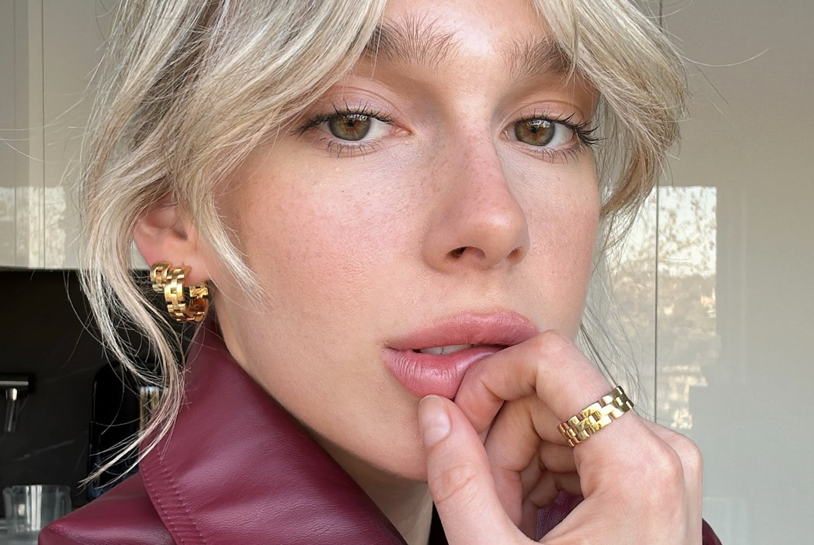 chloe wheatland wearing gold earrings, huggies and ring by reliquia jewellery