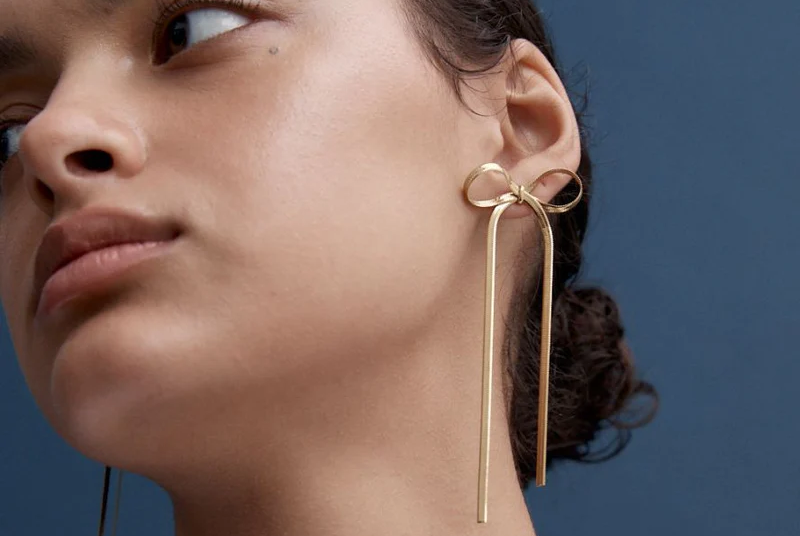 wearing the kayla bow earrings in gold by reliquia jewellery